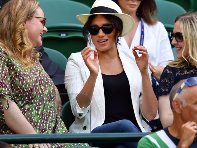 The Duchess of Sussex watches US player Serena Williams playing against Slovakia's Kaja Juvan with old university friends, Lindsay Roth and Genevieve Hillis. Picture: GLYN KIRK / AFP.