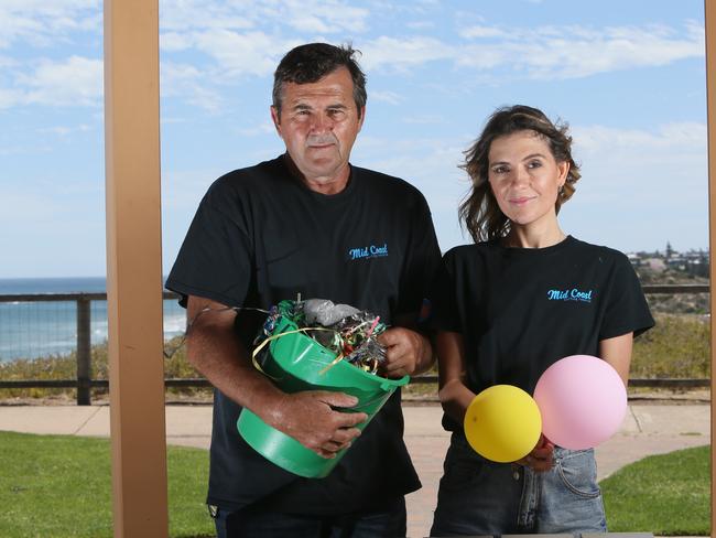 Balloons have been banned at Onkaparinga Council events in South Australia, to protect native and marine wildlife from the deadly effects of latex remnants. Chris Lemar and Carly Lynch with some discarded balloon and party rubbish which they and others collected along the beach and ocean. Picture: AAP/Emma Brasier