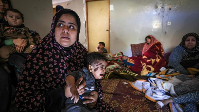 A Palestinian family who survived an Israeli bombardment, rest at a house after receiving treatment at a nearby hospital. Picture: Mahmud Hams