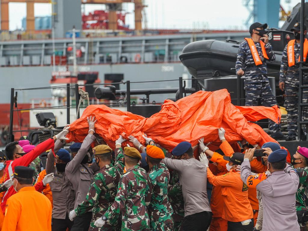 Rescue workers carry recovered debris and body parts at the port in Jakarta on January 10, 2021, during the search operation for Sriwijaya Air flight SJY182. Picture: AFP