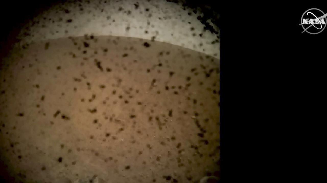 Debris seen on the lens in the first image from NASA's InSight lander after it touched down on the surface of Mars. Picture: AFP/NASA