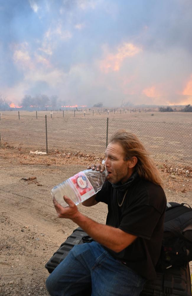 A man who got out of the fire zone gets water as the plume of smoke from the Hughes fire fills the sky in Castaic. Picture: AFP