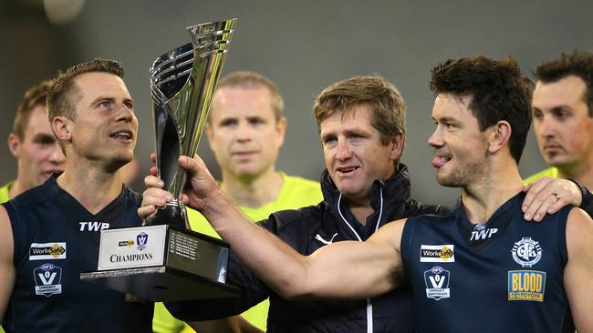 Geelong coach Jeremy Dyer shows off the trophy with players Brandon Howarth (left) and Tim Sheringham. Picture: Wayne Ludbey