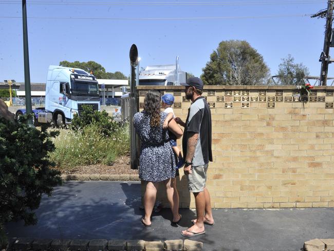 Families lay flowers and wreaths at the Truck Memorial at South Grafton.