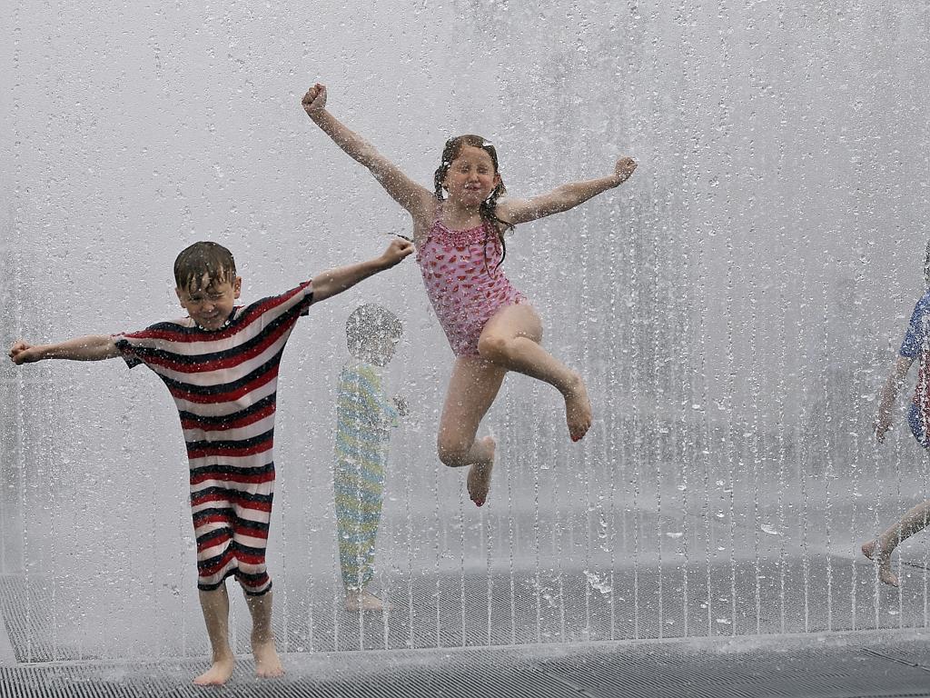 Lukas and Rosa enjoy the refreshing fountain in Southbank, London, Wednesday, July 1, 2015. Picture: AP