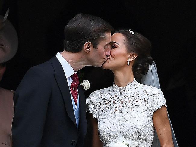 Pippa Middleton (centre R) kisses her new husband James Matthews, following their wedding ceremony at St Mark's Church in Englefield, west of London, on May 20, 2017, as the bridesmaids, including Britain's princess Charlotte (L) and pageboys, including Britain's prince George (2R), walk ahead. After turning heads at her sister Kate's wedding to Prince William, Pippa Middleton graduated from bridesmaid to bride on Saturday at a star-studded wedding in an English country church. The 33-year-old married financier James Matthews, 41, at a ceremony attended by the royal couple and tennis star Roger Federer, wearing a couture dress by British designer Giles Deacon.  / AFP PHOTO / POOL / Justin TALLIS