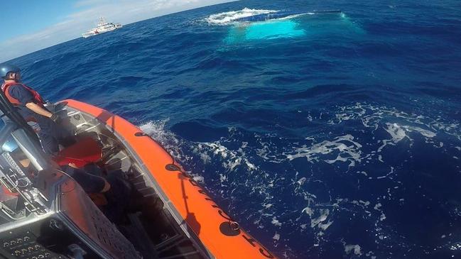 Rescuers search near the sinking vessel.