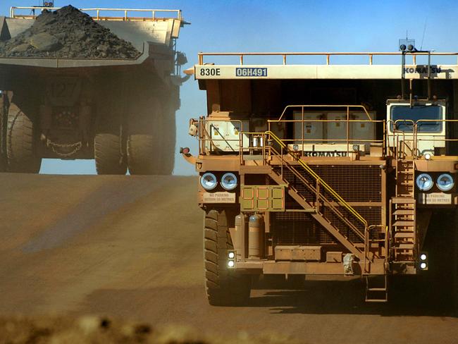 Heavy earth moving trucks at the Tom Price iron ore mine, operated by Rio Tinto Group in Pilbara, WA 26 Jul 2006.