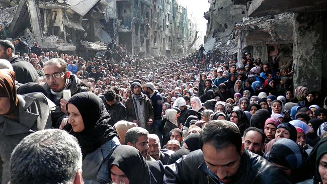 Residents of the besieged Palestinian camp of Yarmouk, queuing to receive food supplies, in Damascus, Syria.