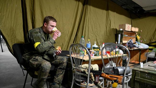 A soldier of Territorial Defense Forces of Ukraine, the military reserve of the Armed Forces of Ukraine, eats his lunch in an underground garage that has been converted into a training and logistics base in Kyiv. Picture: AFP