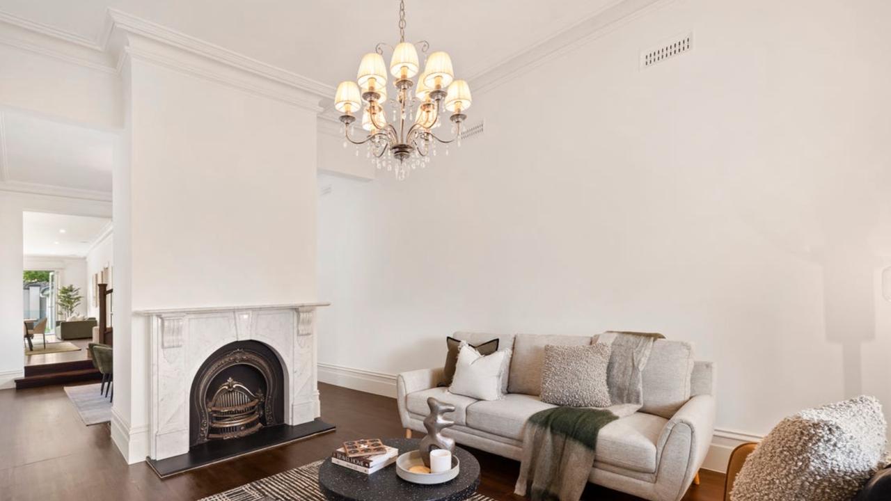 The formal lounge showcases one of several original marble fireplaces preserved during the home’s full-scale renovation.