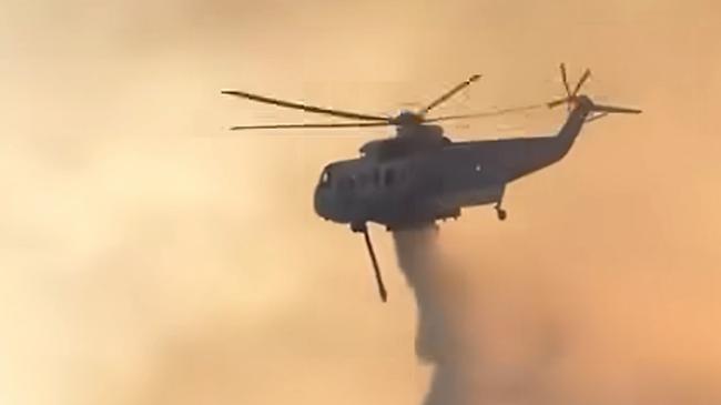 A helicopter drops water on a bushfire burning in the  Grampians. picture: Lexton CFA / Facebook