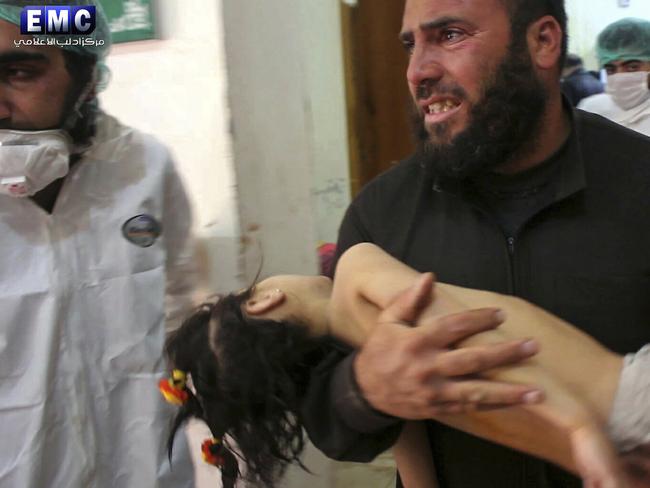 This photo provided by the Syrian anti-government activist group Edlib Media Center shows a man carrying a child following a suspected chemical attack, at a makeshift hospital in the town of Khan Sheikhoun. Picture: Edlib Media Center/AP