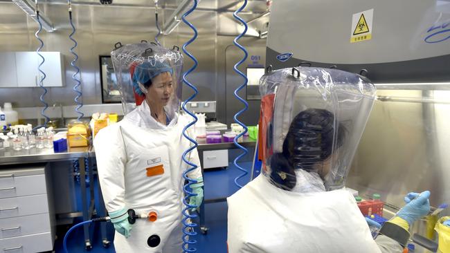 Virologist Shi Zheng-li, left, works with her colleague in the P4 lab of Wuhan Institute of Virology in February, 2017. Picture: Getty Images