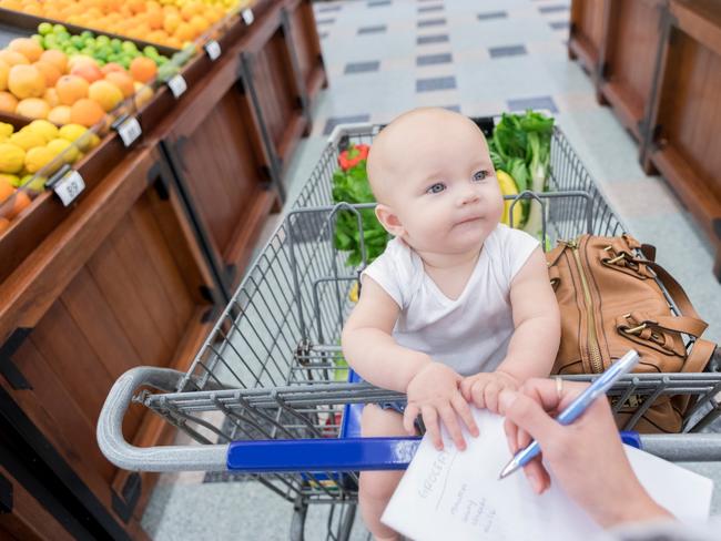 Baby girl smiles at her mom while they shop for fresh produce in a grocery store. supermarket shopping list, groceries generic