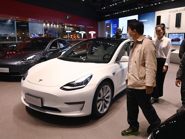 People look at Tesla Model 3 cars in a showroom in Beijing. Picture: AFP