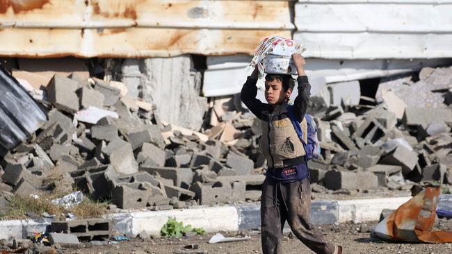 A Palestinian boy carries a container on his head in al-Mughraqa in the central Gaza Strip. Picture: AFP.