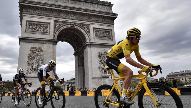 Geraint Thomas (R) rides past the Arc de Triomphe monument during the 21st and last stage of the Tour de France on his way to becoming the first Welshman to win the event. / AFP PHOTO / Marco BERTORELLO