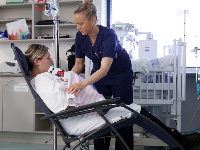 Ms Van Wessem helping new mum Carlene Abe cuddle son Kaycen. Picture: Sam Ruttyn