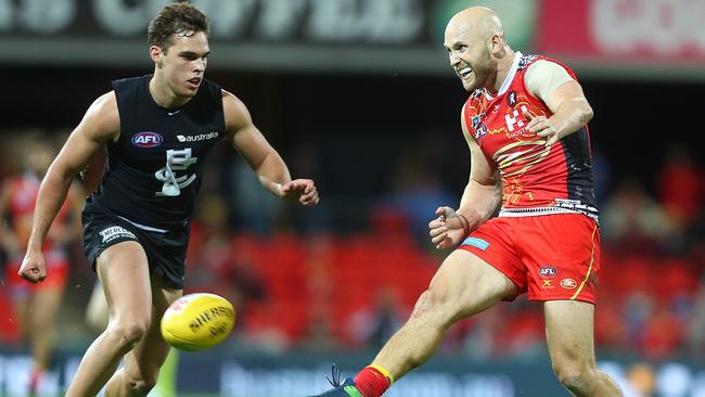 Gary Ablett gets a kick away under pressure from David Cuningham.