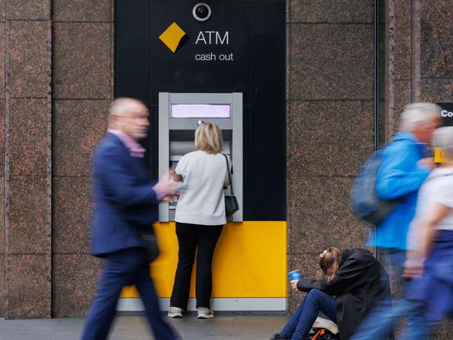 SYDNEY, AUSTRALIA - NewsWire Photos MAY 10 2024. GENERIC. A woman begs for money next to a Commonwealth Bank ATM in Sydney. Economy, cost of living, budget, poverty, homeless, banking. Picture: NCA NewsWire / Max Mason-Hubers