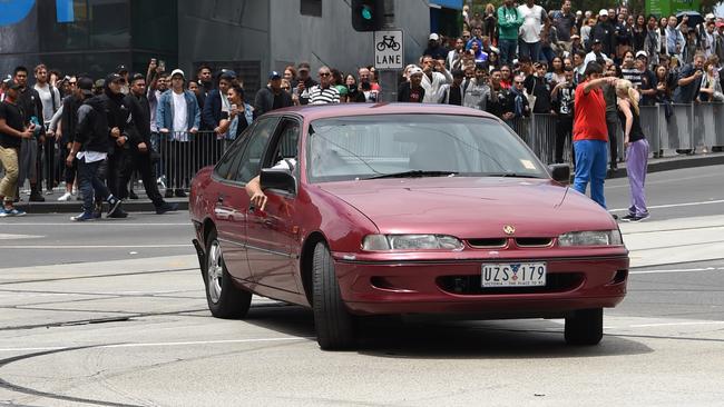 Stunned crowds watch on as the car performs laps outside Federation Square. Picture: Tony Gough