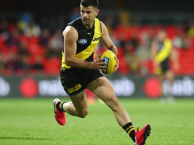 GOLD COAST, AUSTRALIA - AUGUST 04: Trent Cotchin of the Tigers runs the ball during the round 10 AFL match between the Richmond Tigers and the Brisbane Lions at Metricon Stadium on August 04, 2020 in Gold Coast, Australia. (Photo by Chris Hyde/Getty Images)