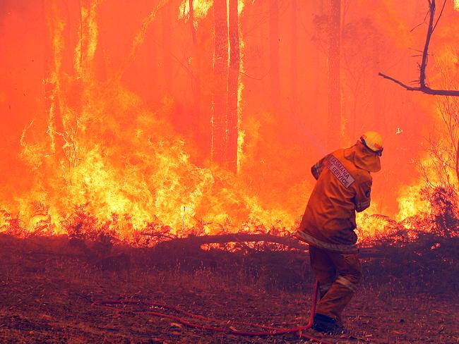 Bushfire near Coningham, a firefighter struggles to contain the blaze on a threatened property