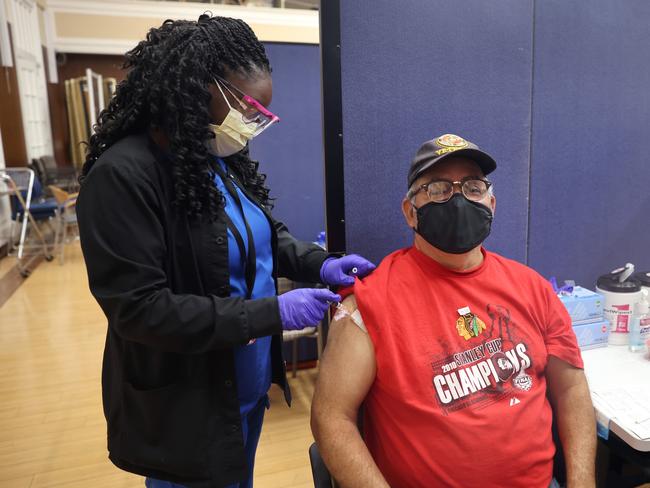 Gloria Clemons administers a booster vaccine and an influenza vaccine to a Marine Corps veteran in Illinois. Picture: Getty Images/AFP