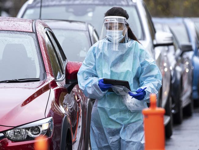 Staff wearing PPE are seen among massive queues at a pop-up Covid test site at Albert Park Lake in Melbourne. Picture: Daniel Pockett/Getty Images