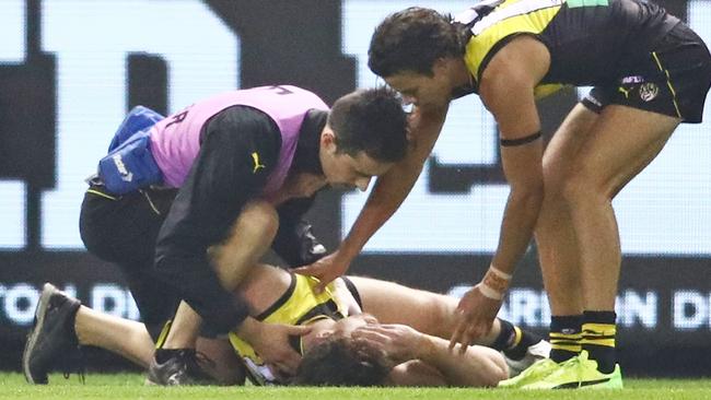 MELBOURNE, AUSTRALIA - JUNE 28: Reece Conca of the Tigers leaves the field injured as Daniel Rioli of the Tigers looks on during the round 15 AFL match between the Richmond Tigers and the Sydney Swans at Etihad Stadium on June 28, 2018 in Melbourne, Australia. (Photo by Scott Barbour/Getty Images)