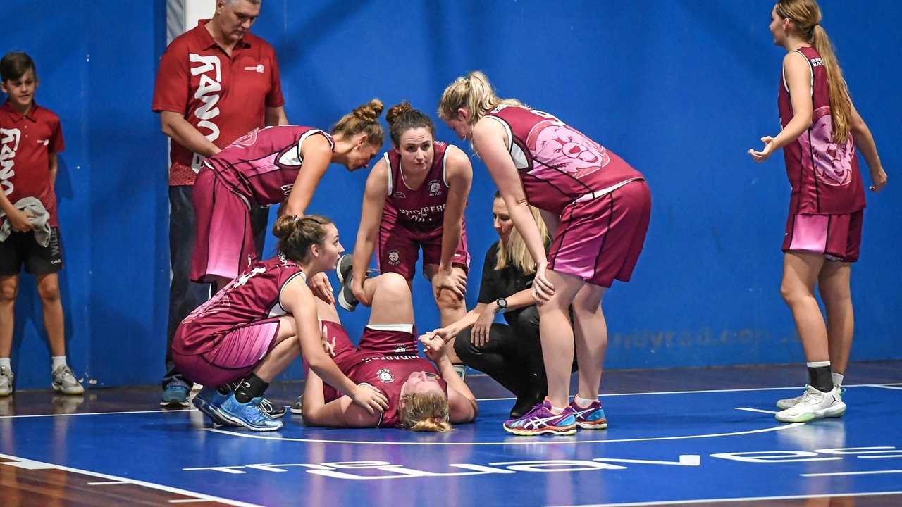 Stef Rehbein's teammates gather around after she suffers a leg injury. Picture: Brian Cassidy