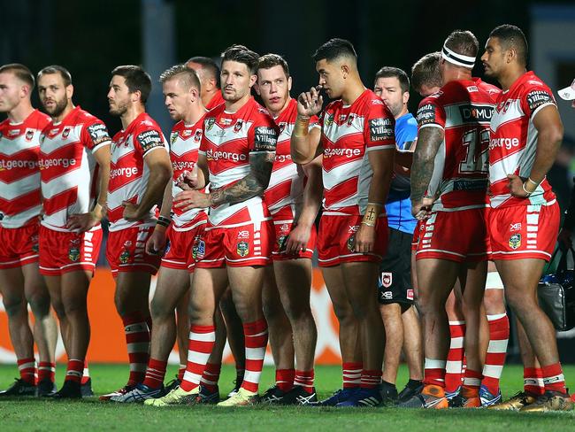 Dragons players watch after the Warriors score a try.