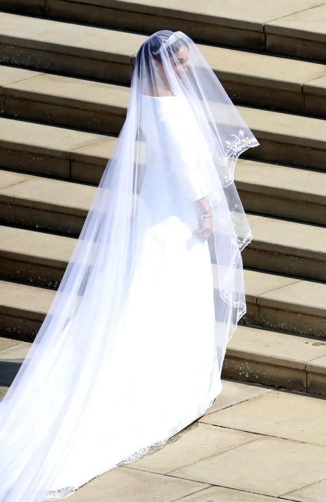 Meghan Markle gives the world the first full glimpse of her dress, designed by Clare Waight Keller of Givenchy,  as she walks up the steps of St George’s Chapel.