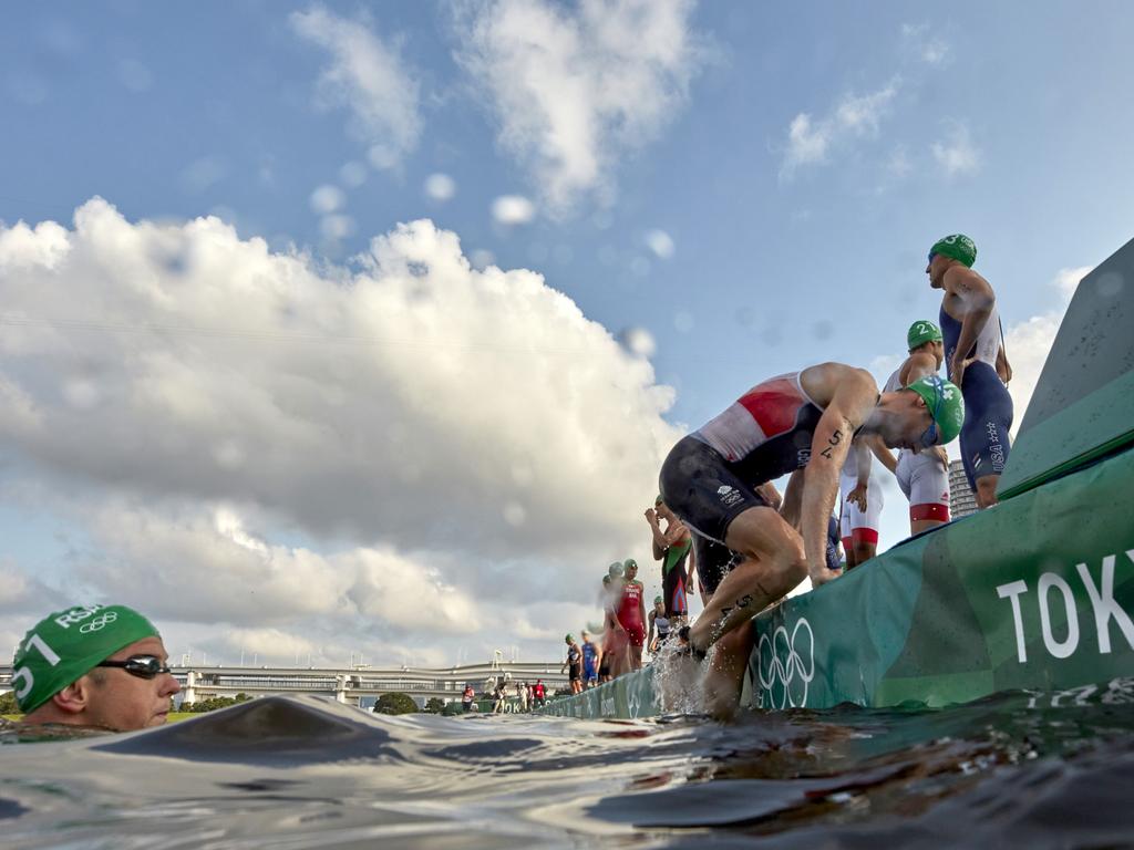 Triathletes climb back onto shore after a broadcast boat in the water forced a restart before the Men's Individual Triathlon on day three of the Tokyo 2020 Olympic Games. Picture: Getty Images