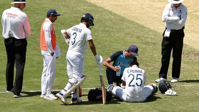 Pujara receives attention to a busted finger late on day five. Picture: Getty