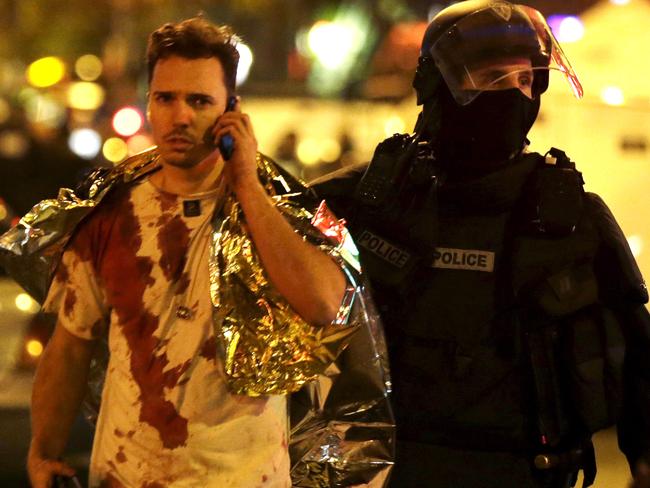 Attack ... A French policeman assists a blood-covered victim near the Bataclan concert hall following attacks in Paris in November.  Picture:  Reuters