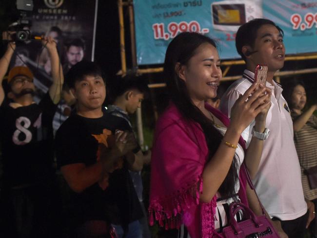 Delighted onlookers watch an ambulance apparently carrying some of the rescued boys leaving the airport. Picture: AFP Photo / Ye Aung Thu