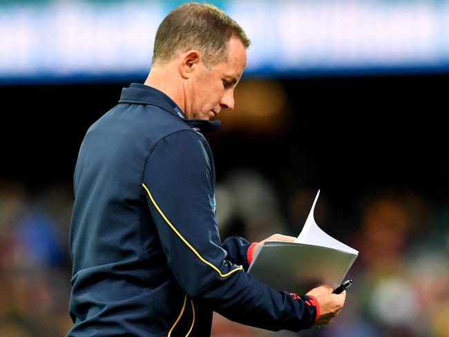 Crows coach Don Pyke looks at his notes during a break during against North Melbourne.