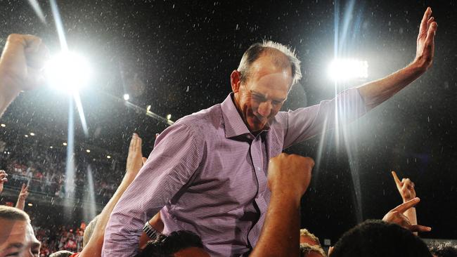 Wayne Bennett is chaired by Dragons players as they present the Premiership trophy to supporters. Photo: Braden Fastier