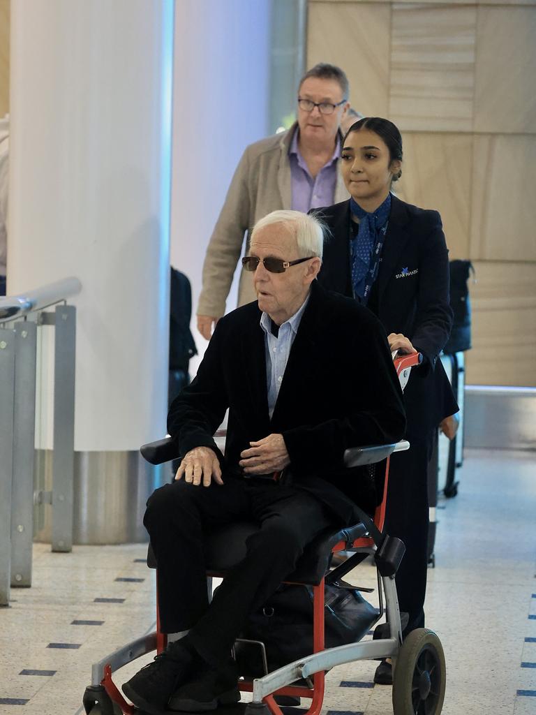 Paul Hogan is wheeled out of Sydney Airport.
