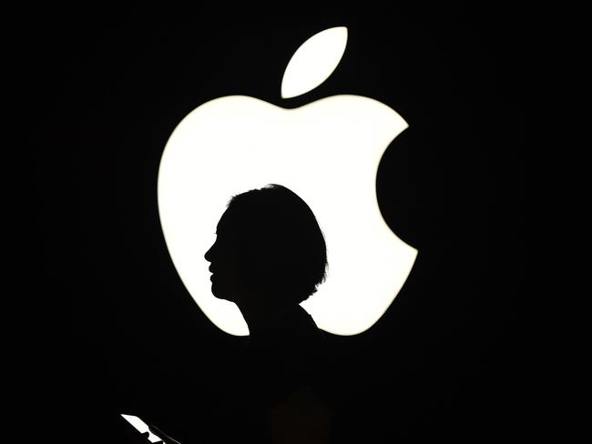 (FILES) In this file photo taken on September 09, 2015 a reporter walks by an Apple logo during a media event in San Francisco, California. - Apple on July 30, 2020, reported higher profits in the past quarter, with strong gains in sales of wearables, accessories and services amid a global pandemic. (Photo by Josh Edelson / AFP)