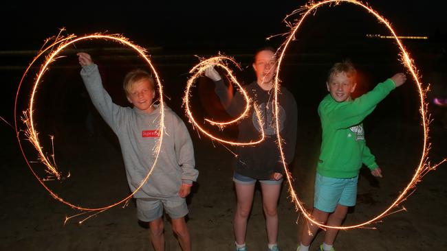 Lachlan Lewis, Henry Salisbury, Madeleine Salisbury with sparklers on the Lorne beach. Picture: David Crosling