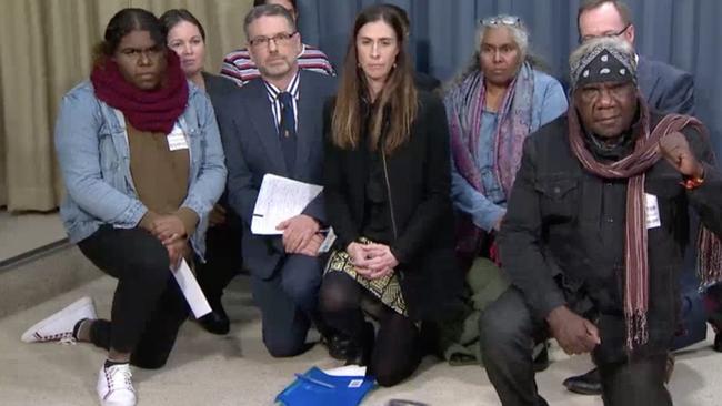 The family of the boy kneel at a press conference with Greens MP David Shoebridge calling for the officer’s arrest.