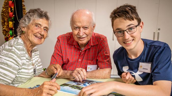 James Thorburn, 15, helps Ian Milton and Margaret Daff with a puzzle at the Umbrella Dementia Cafe. Picture: Jake Nowakowski