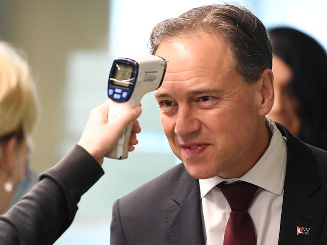 Federal Health Minister Greg Hunt has his temperature checked before touring the Royal Melbourne Hospital in Melbourne last month. Picture: James Ross/AAP