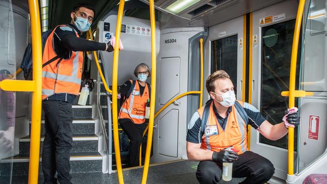 NSW Transport cleaners Rahil Nerkar, Judy Navidi and Andrew Kroenert. Picture: Flavio Brancaleone