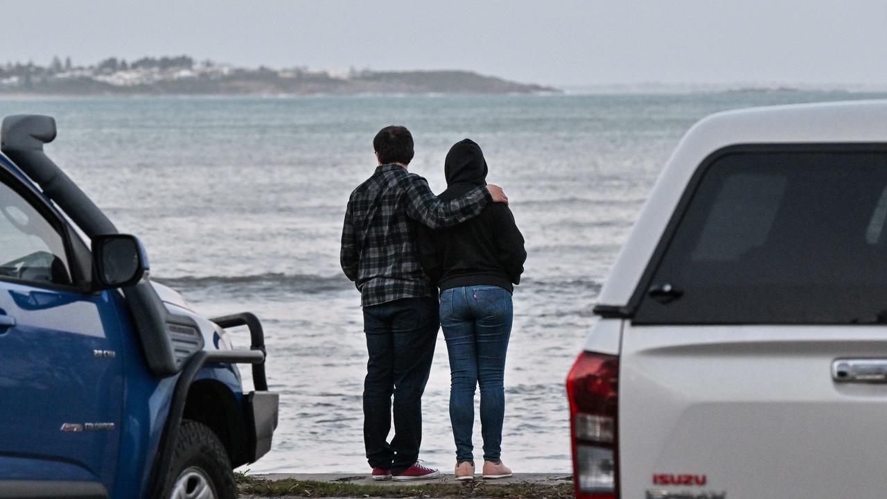 People watch as emergency services search for a 16yo boy who was seen floating in seas on the southern side of Granite Island at Victor Harbor. Picture: Brenton Edwards