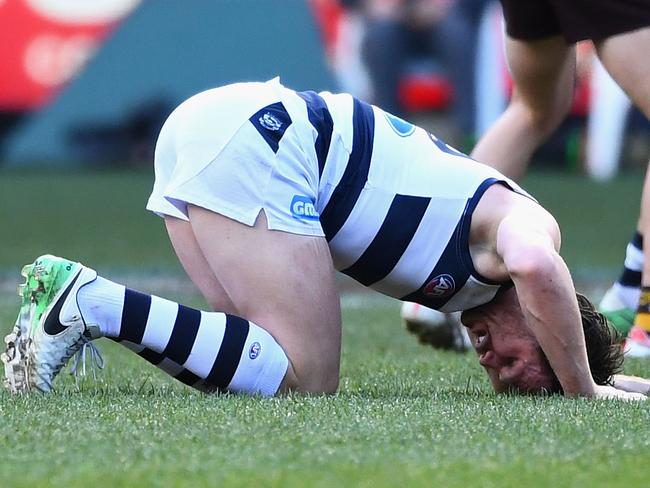 Patrick Dangerfield of the Cats lays on the ground injured.