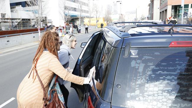 The mother of Jari Wise, Faith Tkalac (red dreadlocks) alongside family and friends yell and at and chase down Jari's former  girlfriend, Melissa Oates as she  leaves Hobart Magistrates Court under police escort  after her court hearing was adjourned.  Picture: Zak Simmonds